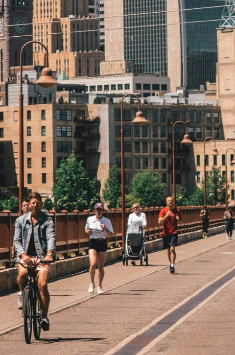 People walking, biking, and running on the Stone Arch Bridge in downtown Minneapolis