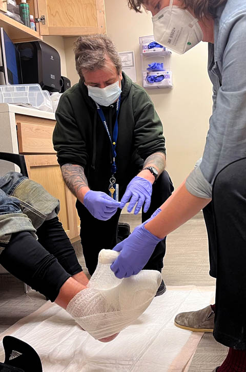 Medical staff bandage a man's feet