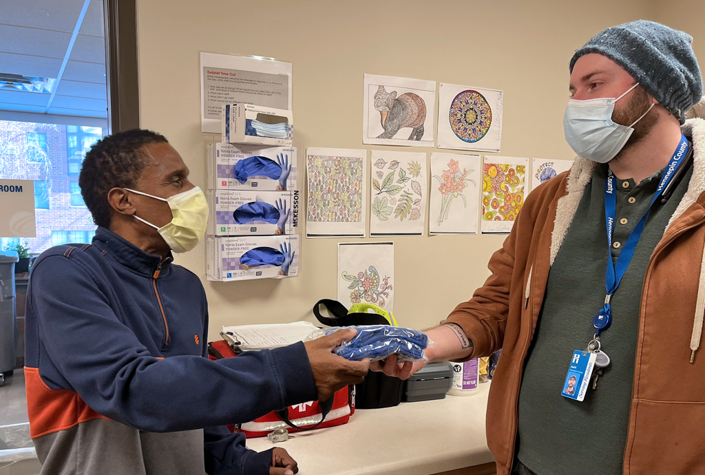 Medical staff give socks to a patient