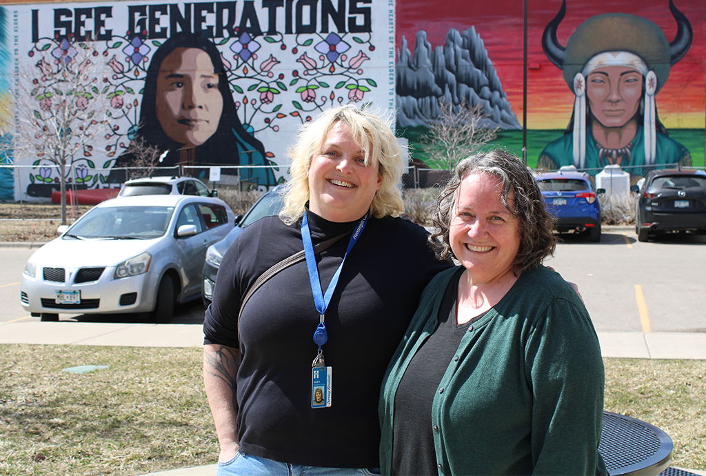 Two people in front of mural