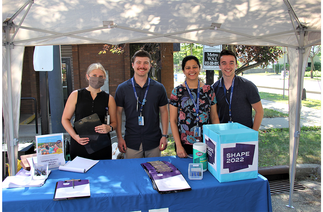 people standing under a tent smiling