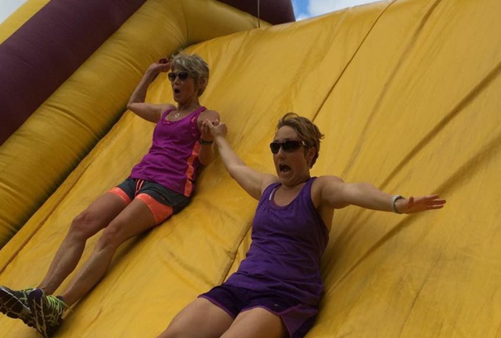 women sliding down a slide