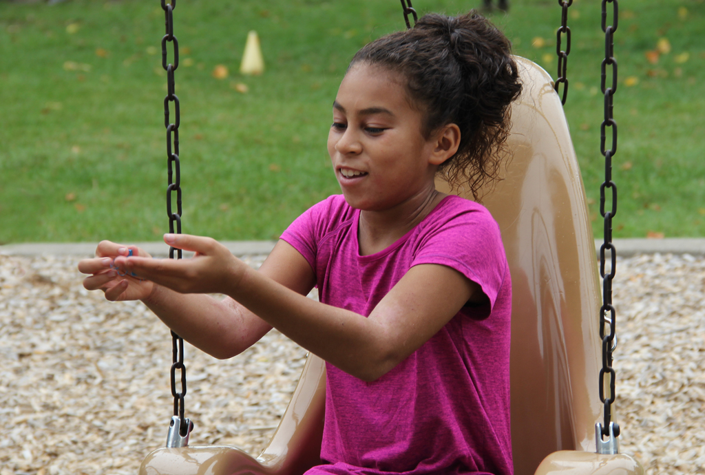 A girl who has taken swim lessons playing in a park