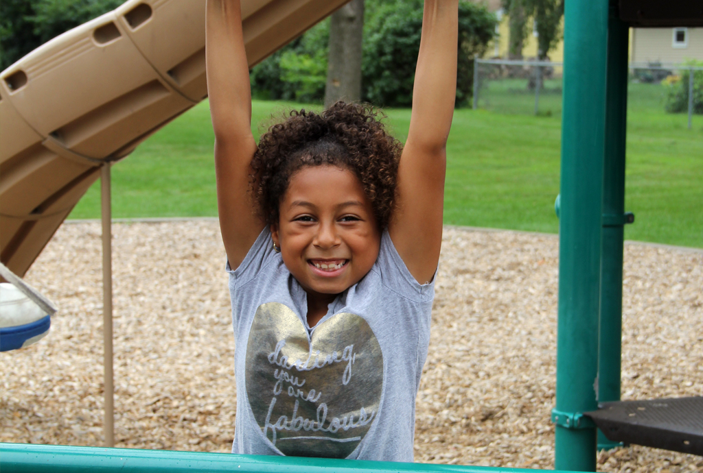 A girl who has taken swim lessons playing in a park